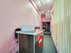 A reception area with a desk, a ceiling fan, and a door in the background. - Hotel O Kanha (Nagpur)