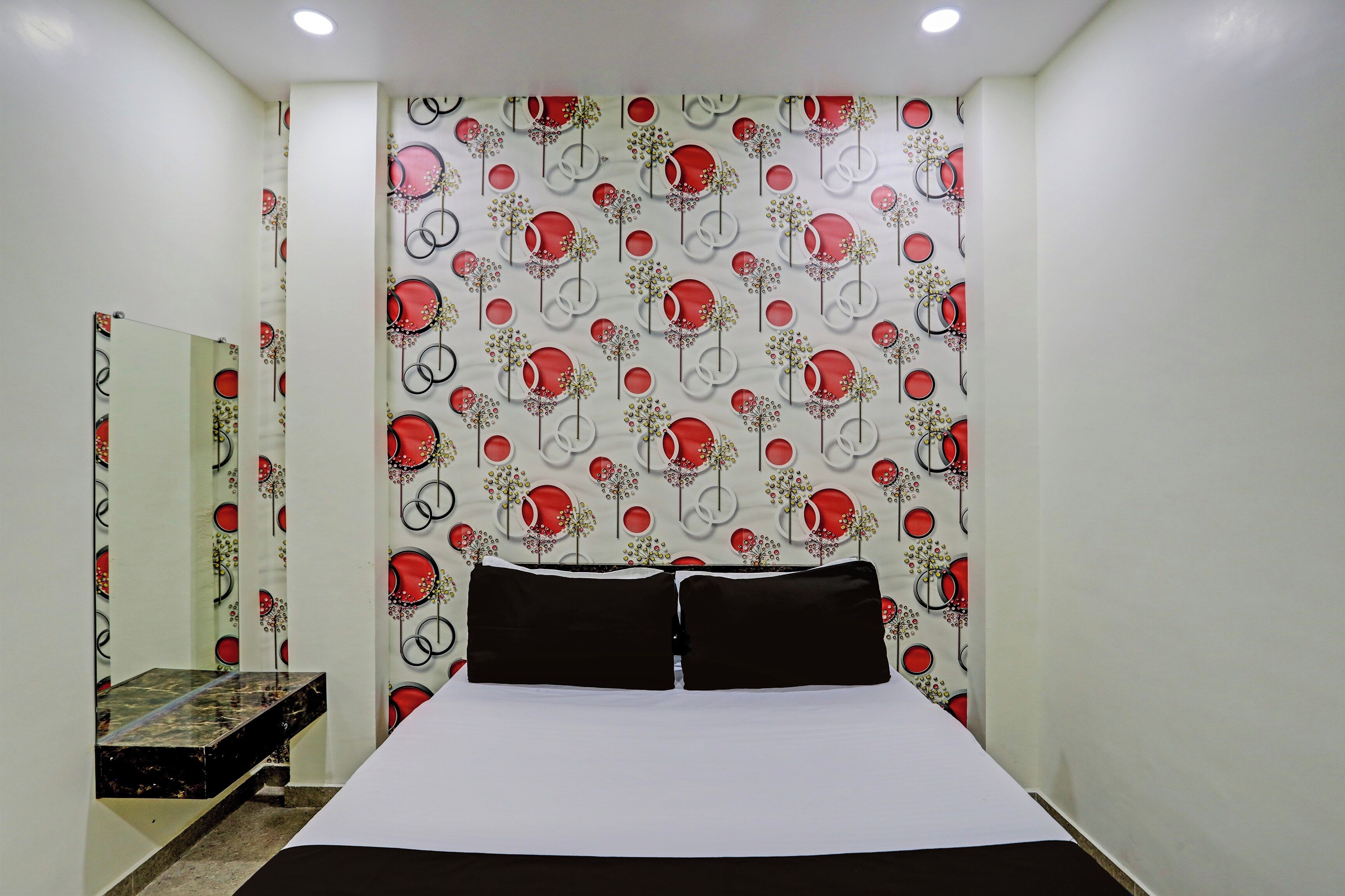 Un dormitorio con una cama, un espejo y una pared con un diseño circular.