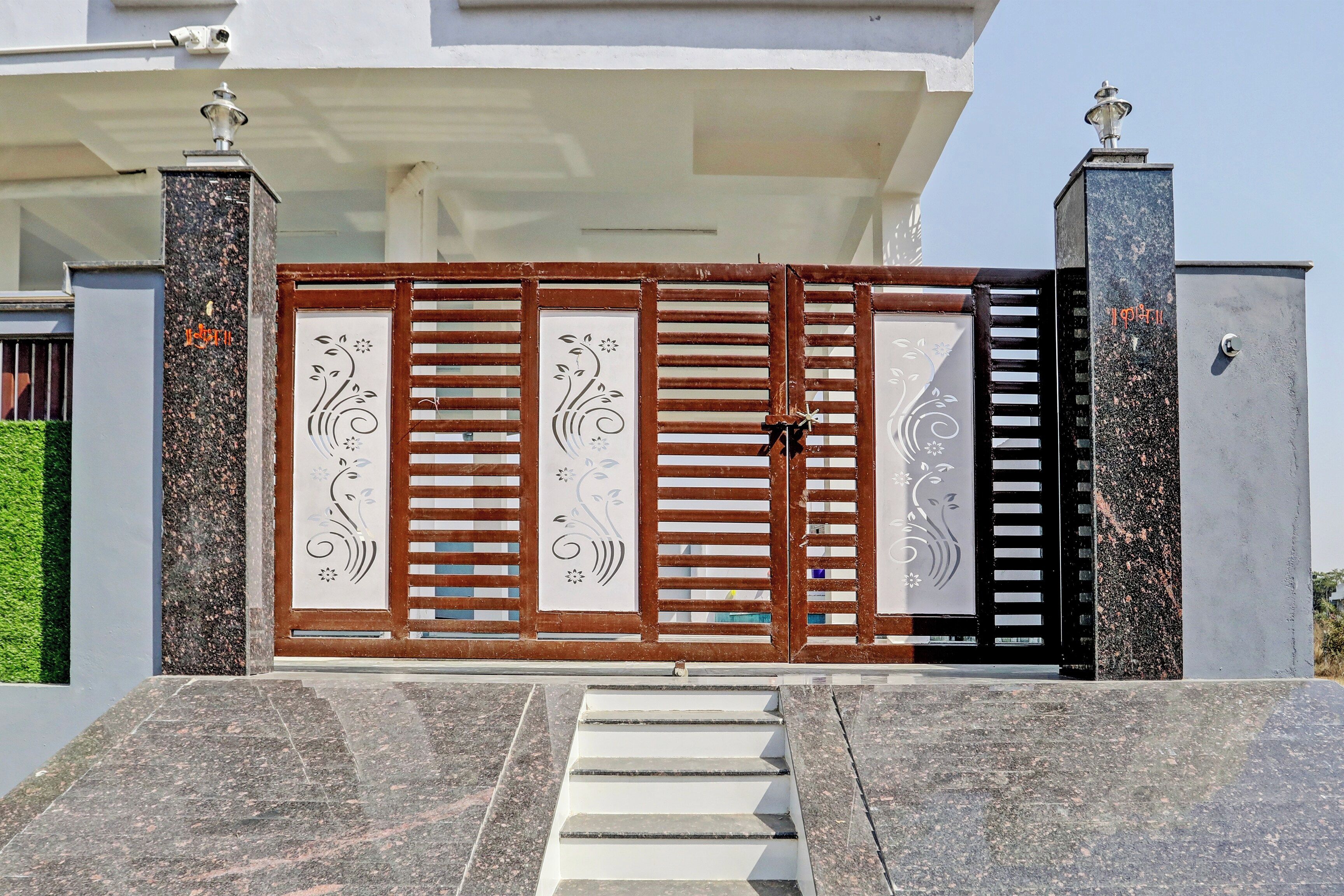 A gated entrance with a decorative gate, steps leading up to it, and a security camera above.