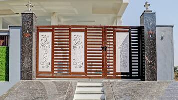 A gated entrance with a decorative gate, steps leading up to it, and a security camera above.