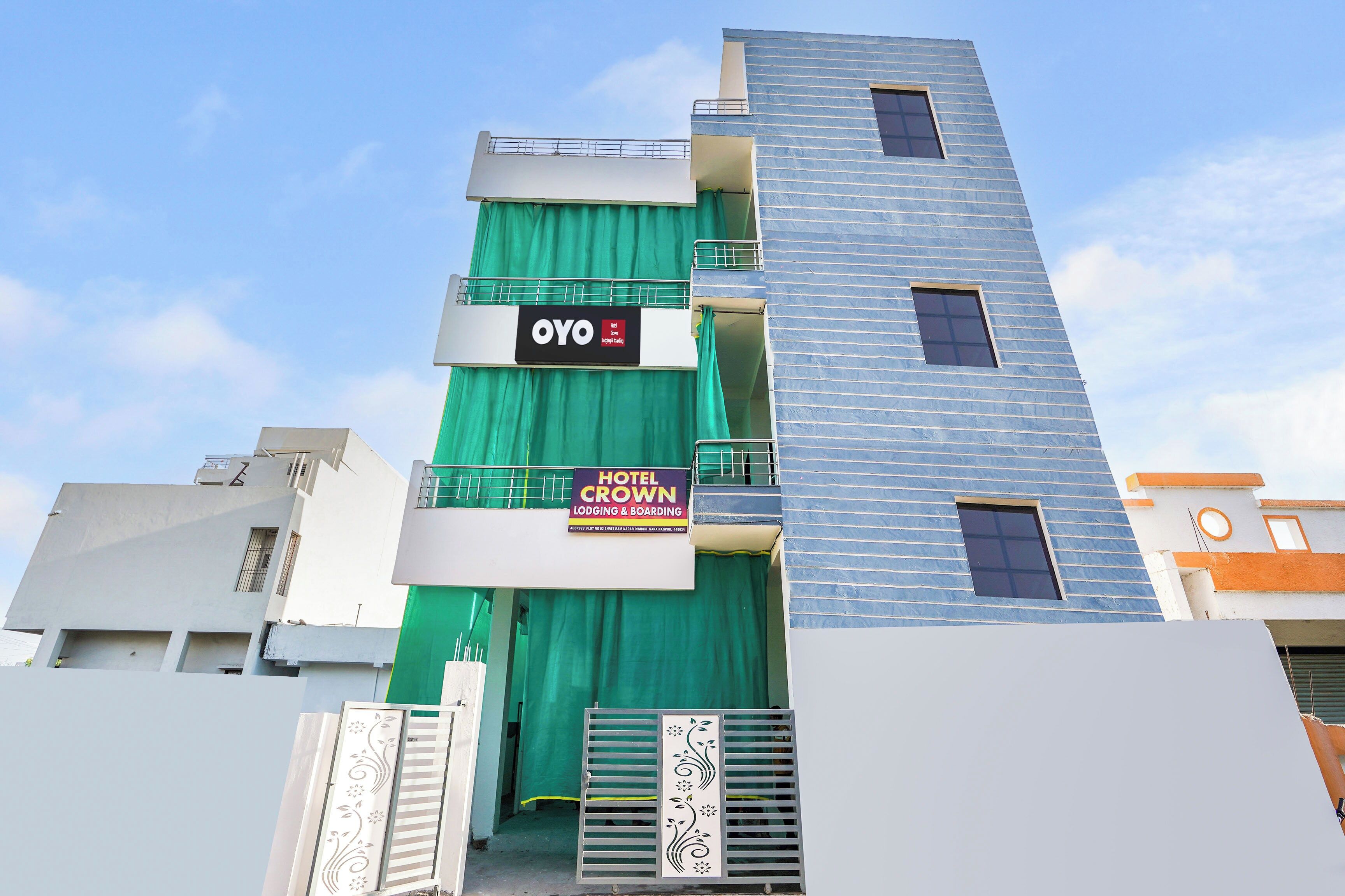 A multi-story building with a sign for 'Hotel Crown Lodging & Boarding' and a 'OYO Hotel' sign.
