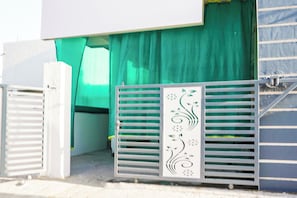 A gated entrance with a decorative metal gate and a green curtain partially covering the door. - Hotel O Crown (Nagpur)