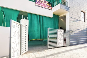 A hotel entrance with a green curtain, a signboard, and decorative gates. - Hotel O Crown (Nagpur)
