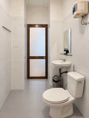Un baño moderno con inodoro, lavamanos y espejo.
