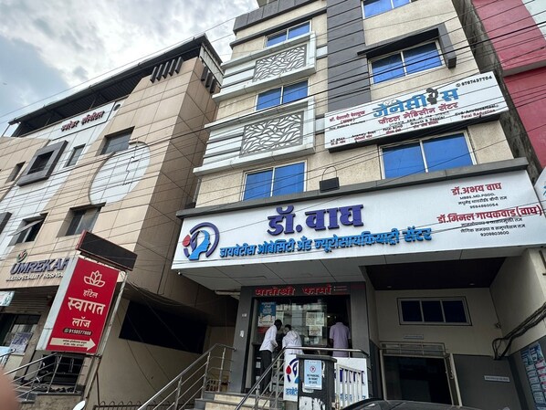 Un edificio de varios pisos con varias indicaciones, incluyendo una para un hospital y otra para una clínica dental.