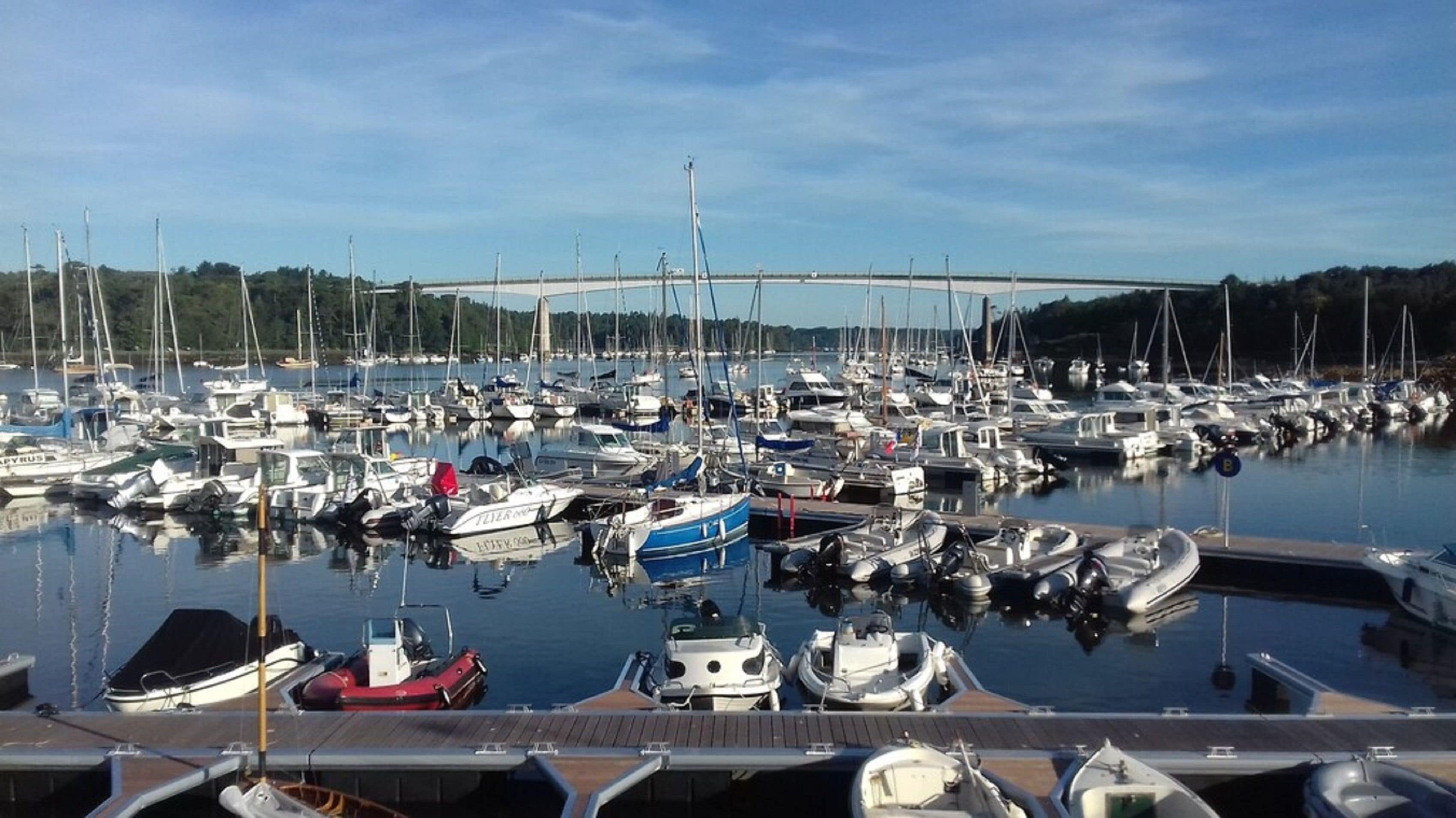 En småbåtshamn full av olika typer av båtar som låg förtöjda vid bryggan.