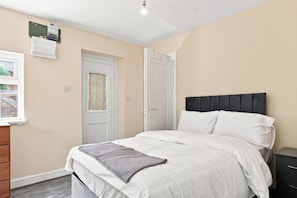 A bedroom with a bed, a dresser, a door, and a window. - Serene 3-bedroom apartment in the heart of Manchester (Manchester)