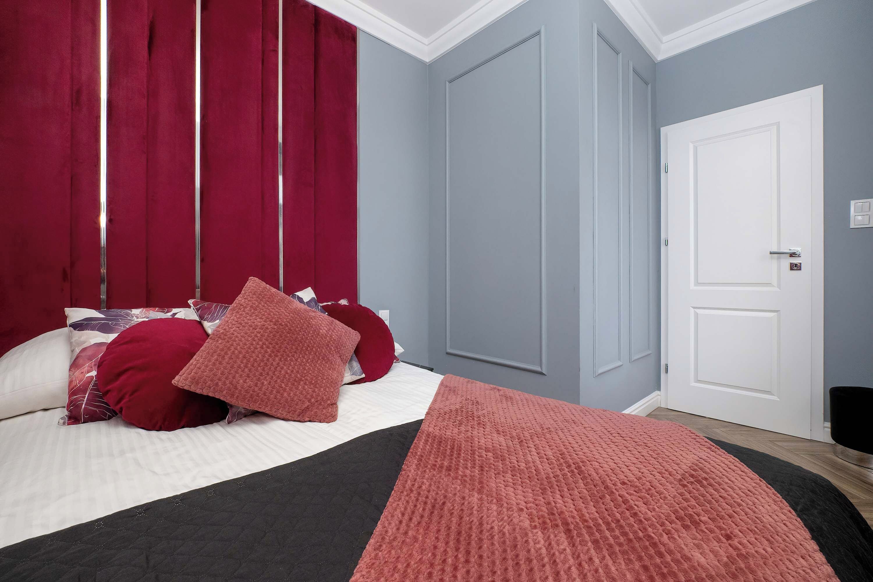 Un dormitorio con cama, almohadas, una colcha y una puerta.