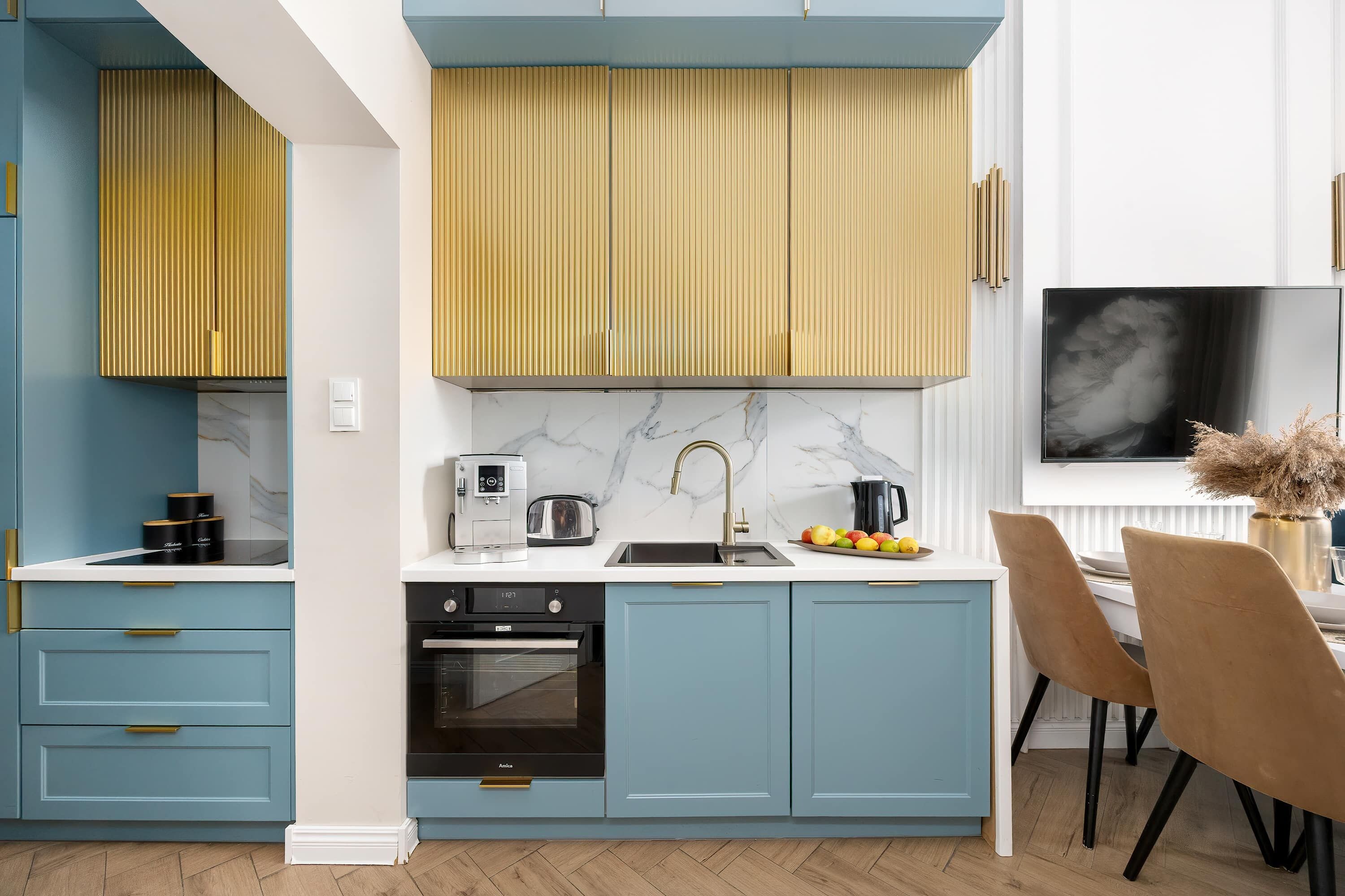 Eine moderne Küche mit blauen Schränken, einem schwarzen Ofen und einer Marmor-Spritzschutzwand.