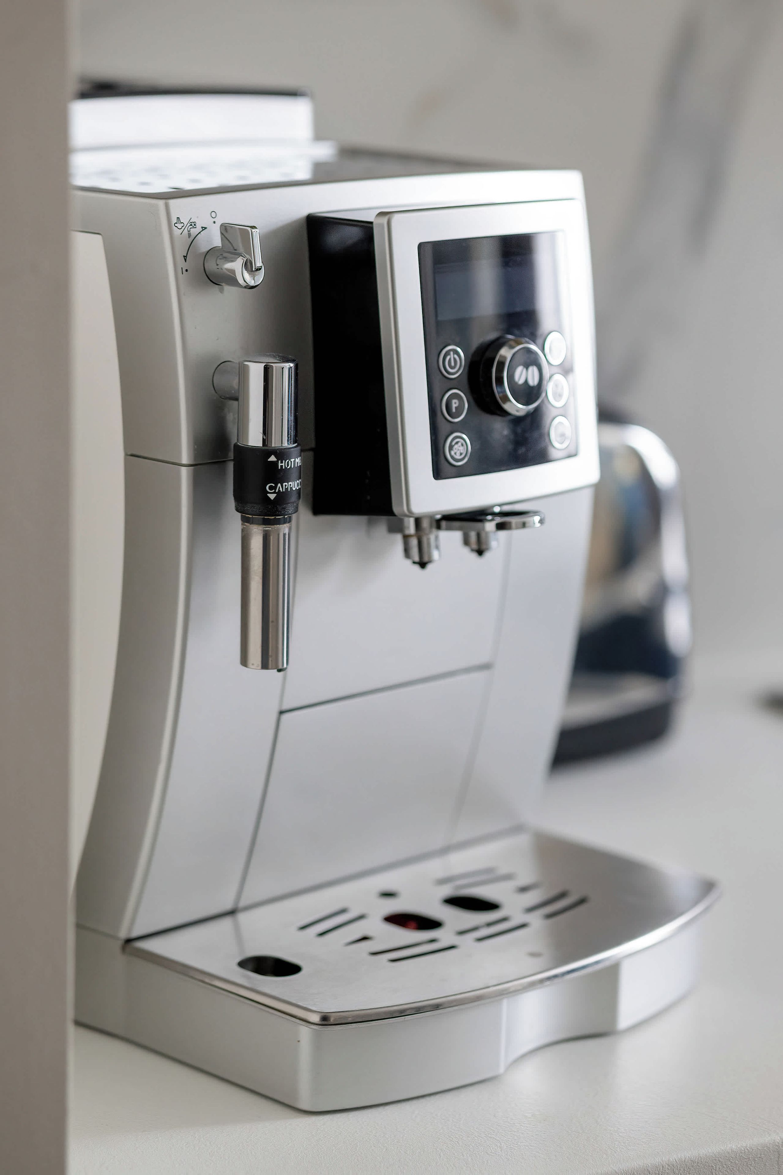 Eine moderne Espressomaschine mit digitalem Display und Dampfstrahl.
