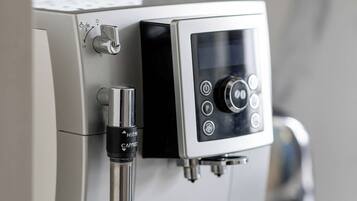 Eine moderne Espressomaschine mit digitalem Display und Dampfstrahl.