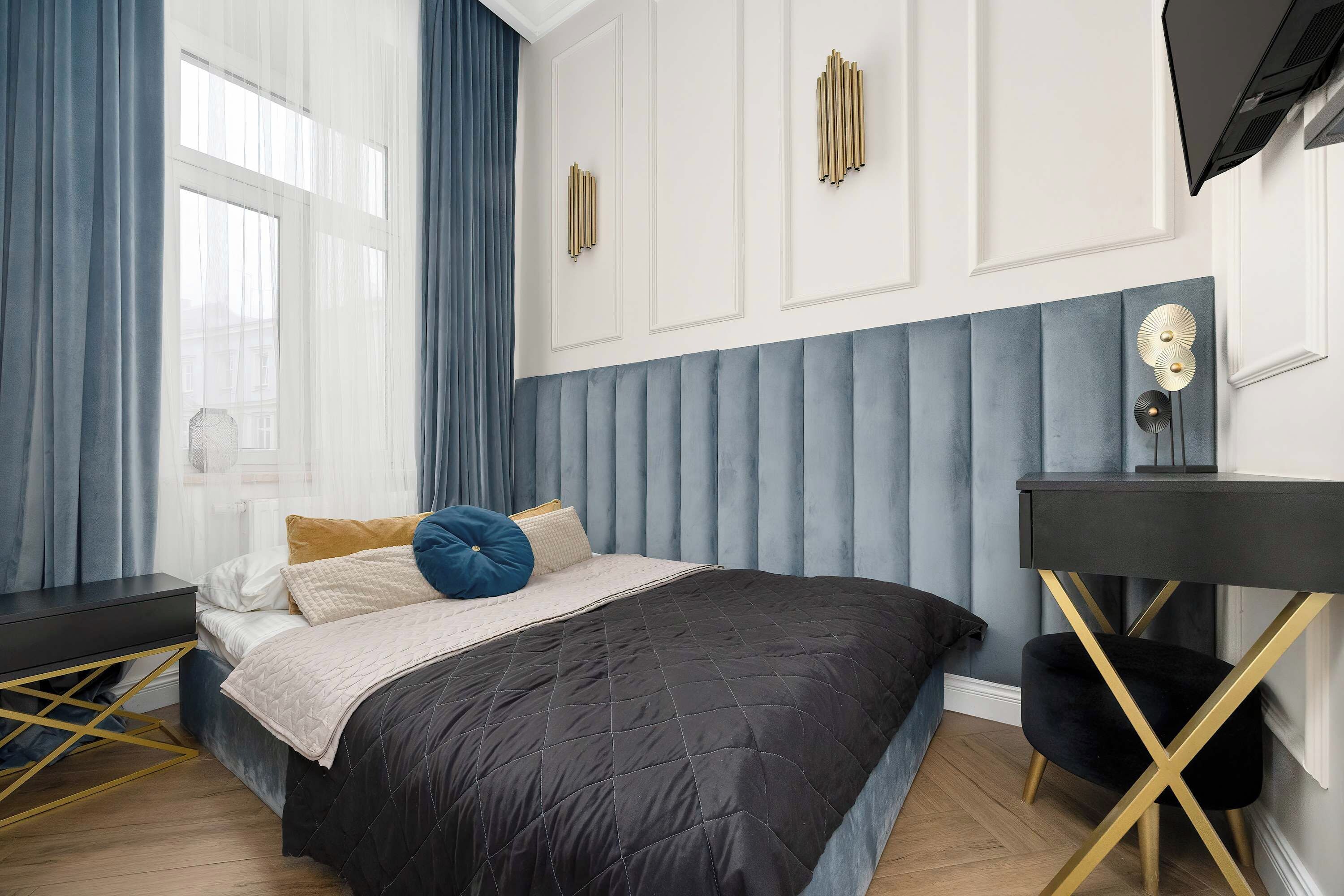 A modern bedroom with a bed, a desk, and a chair.