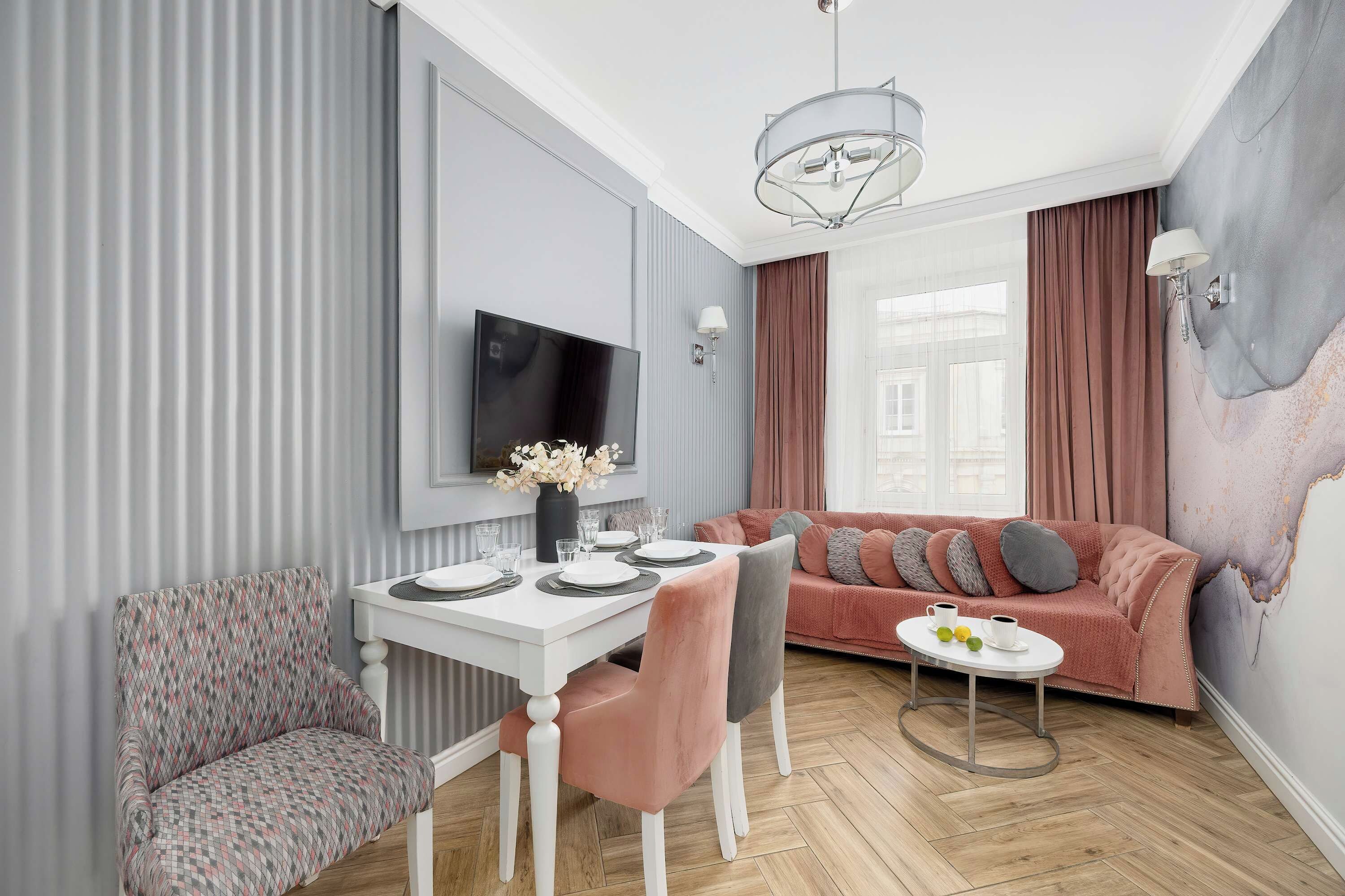 Ein modernes Wohnzimmer mit Essbereich, einer Couch und einem an der Wand montierten Fernseher.