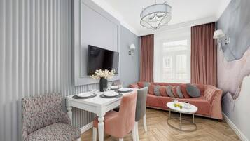 Ett modernt vardagsrum med en matplats, en soffa och en tv som är monterad på väggen.