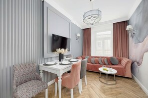 Ett modernt vardagsrum med en matplats, en soffa och en tv som är monterad på väggen.