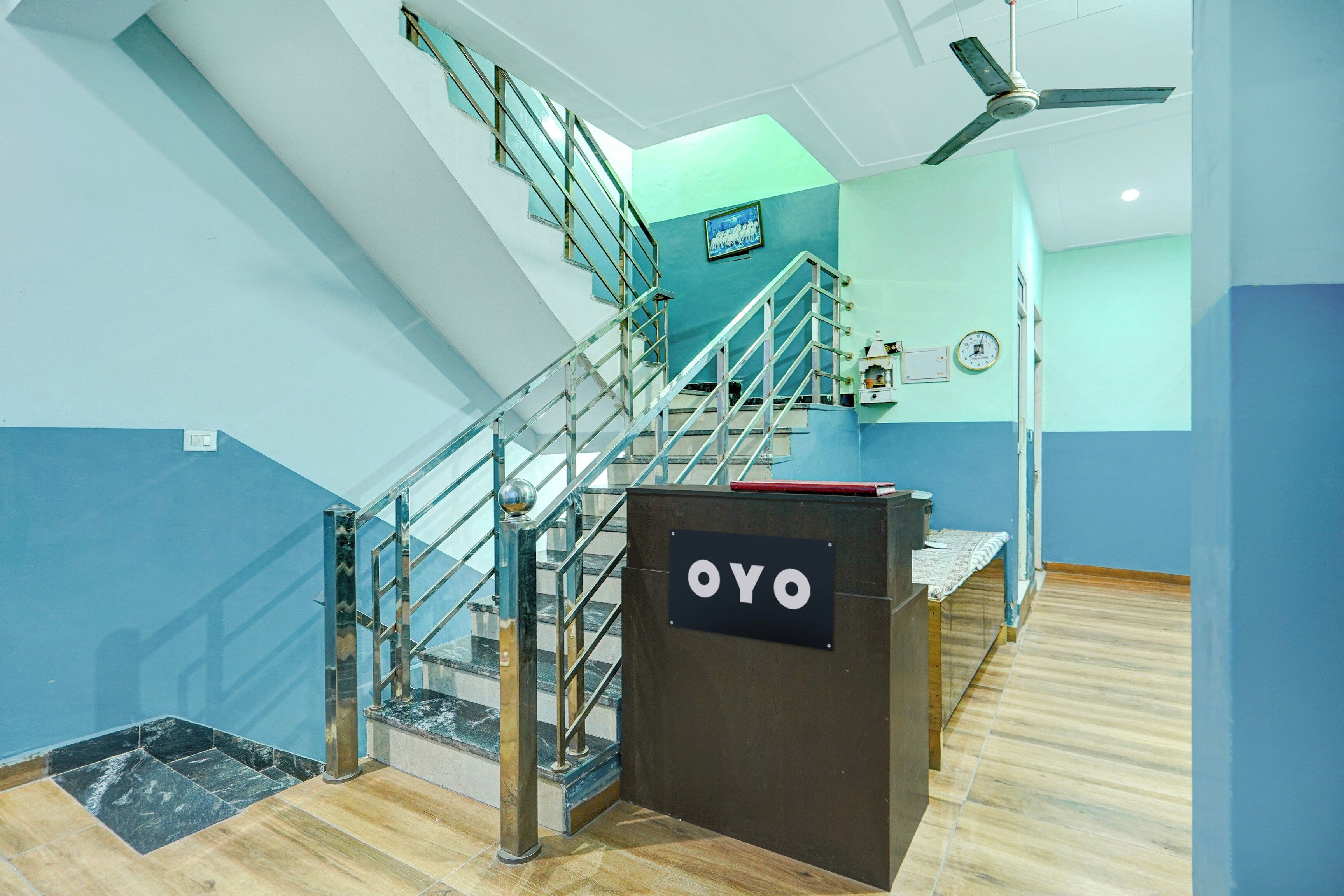 Uma escadaria com guarda-corpos de vidro e uma placa com a inscrição 'OYO'.