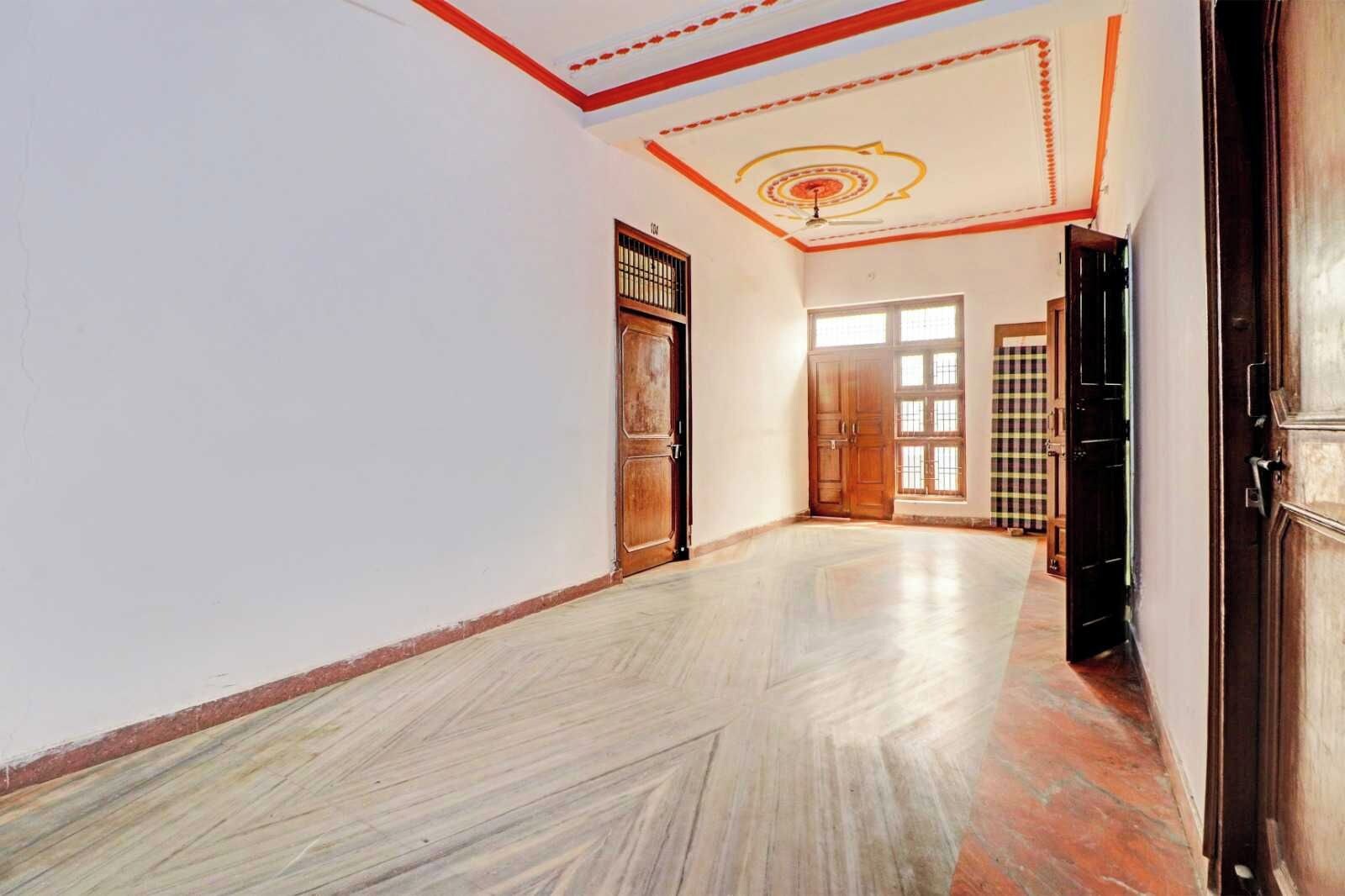 Um corredor com porta de madeira, porta xadrez e janela com vista.