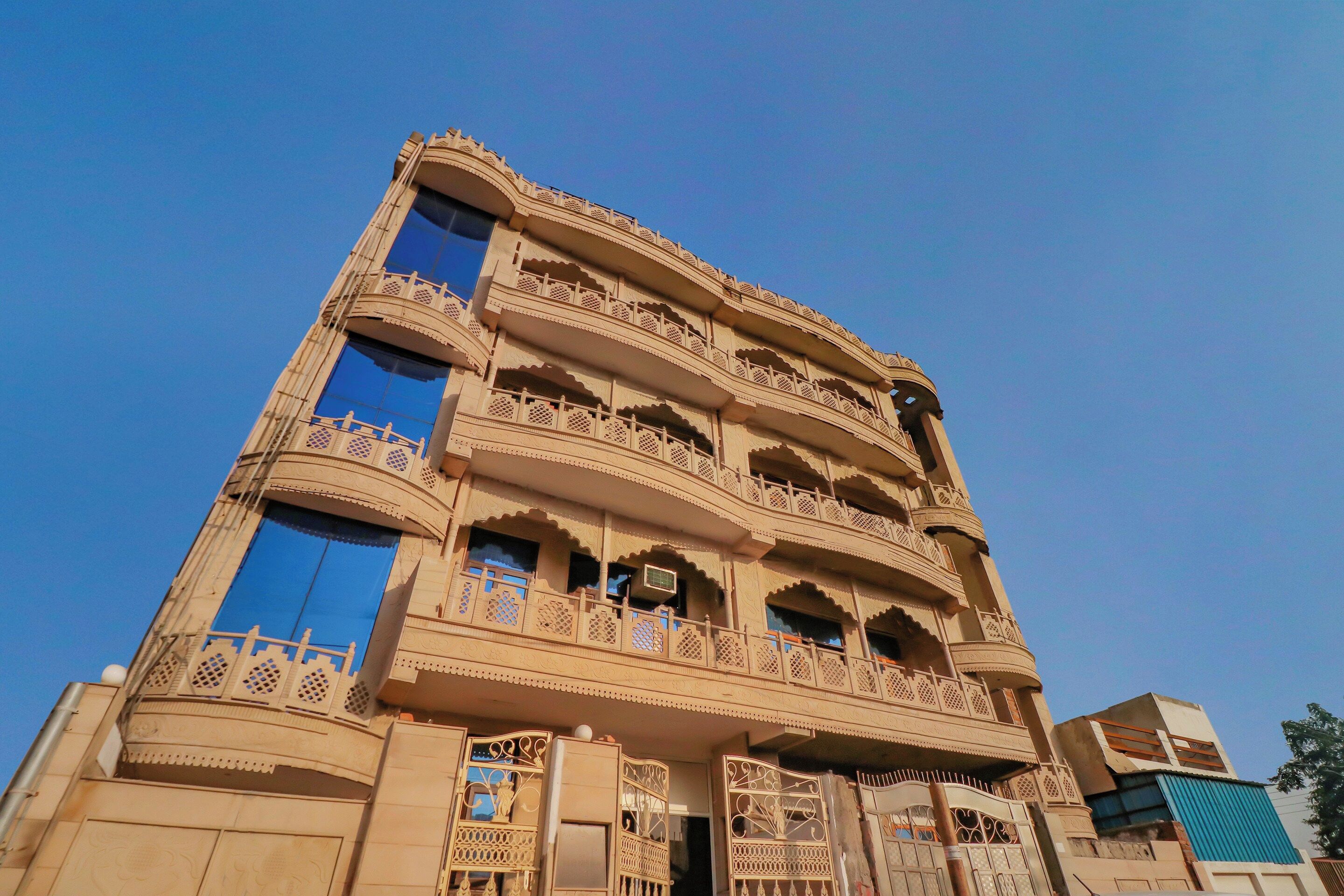 Un immeuble à plusieurs étages, doté de balcons richement décorés et de grandes fenêtres.