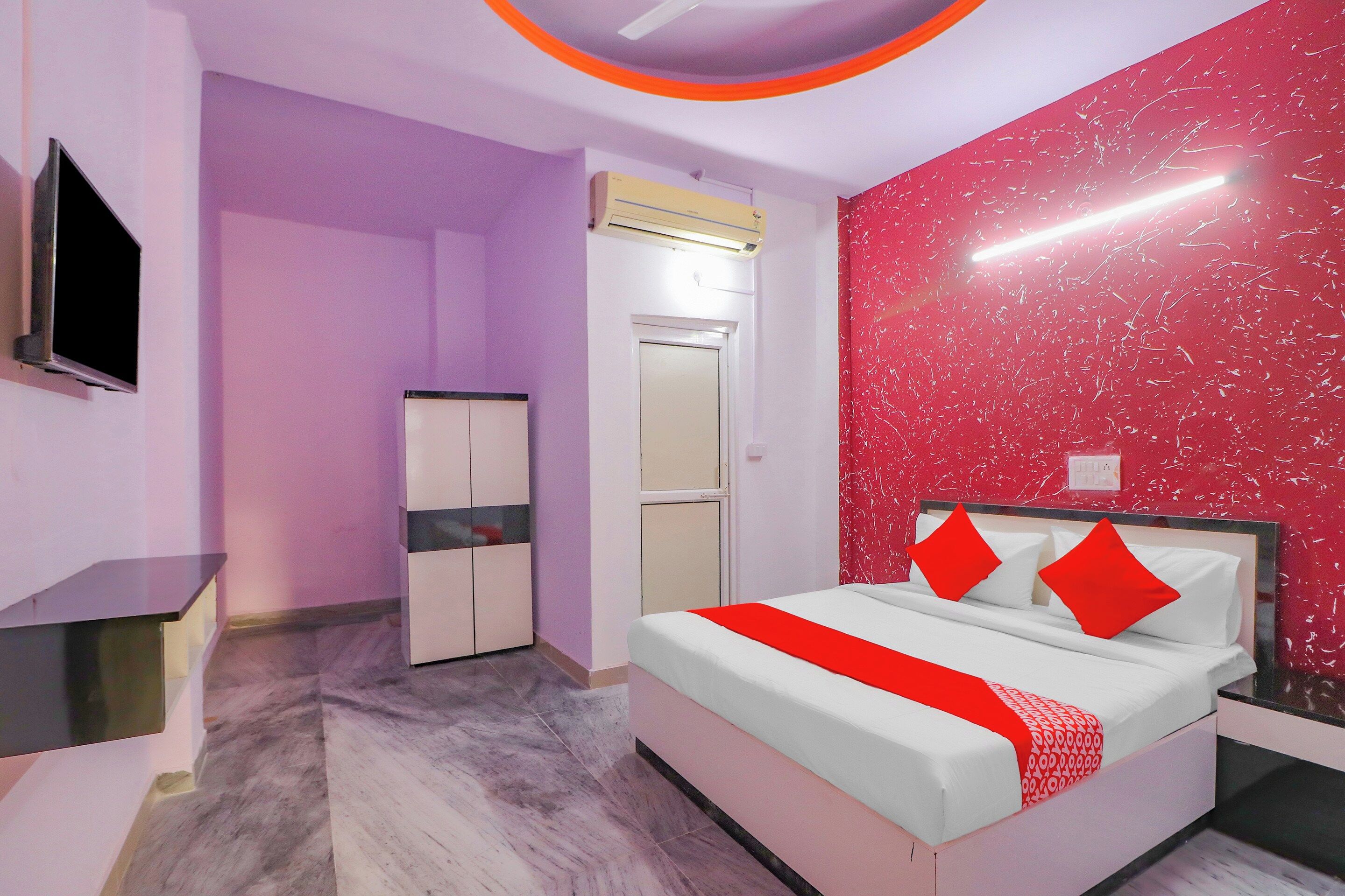 Une chambre à coucher comprenant un lit, une armoire, un téléviseur et un appareil de climatisation.