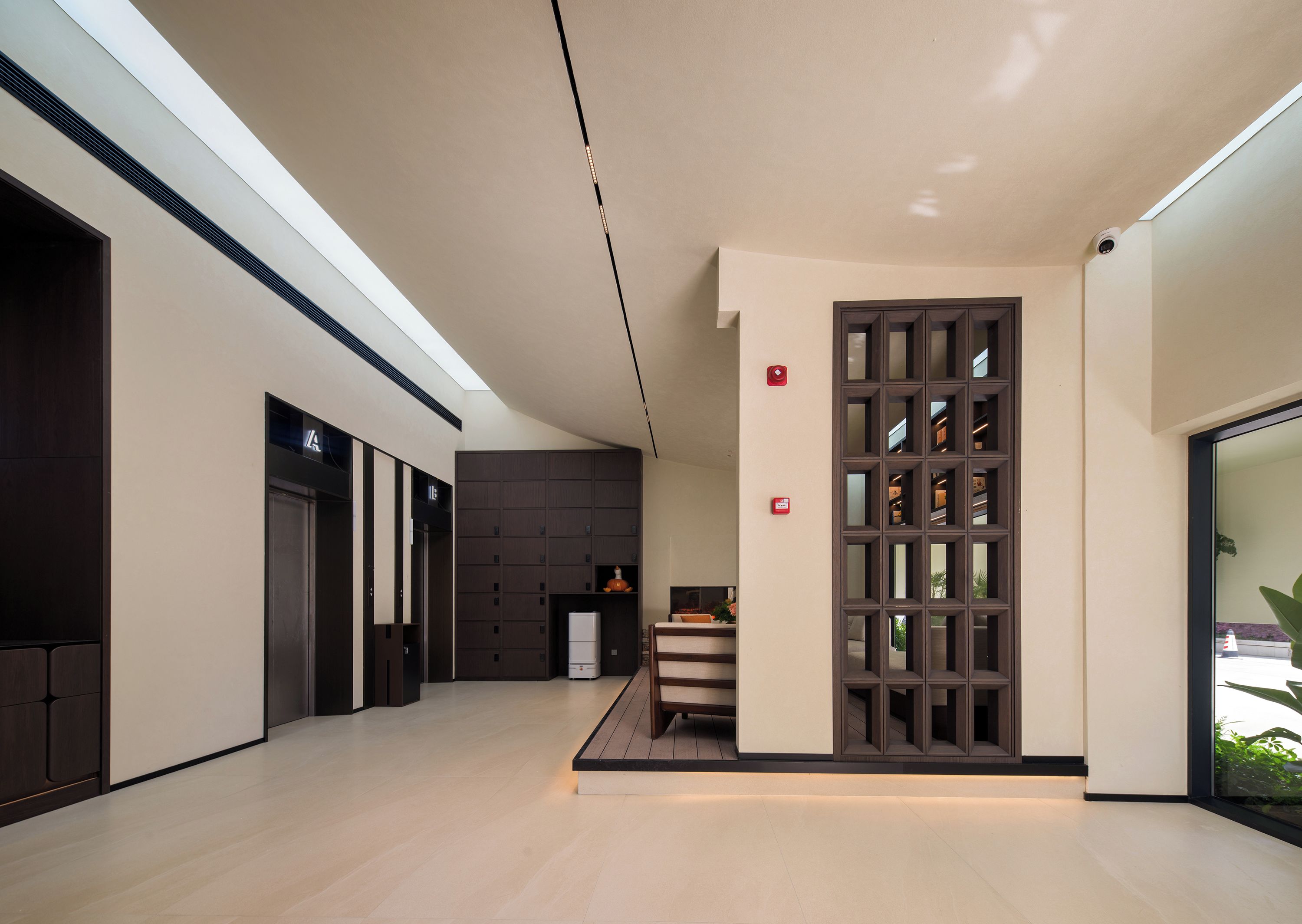 Un interior moderno con una columna central, una escalera y una puerta de cristal que da al exterior.