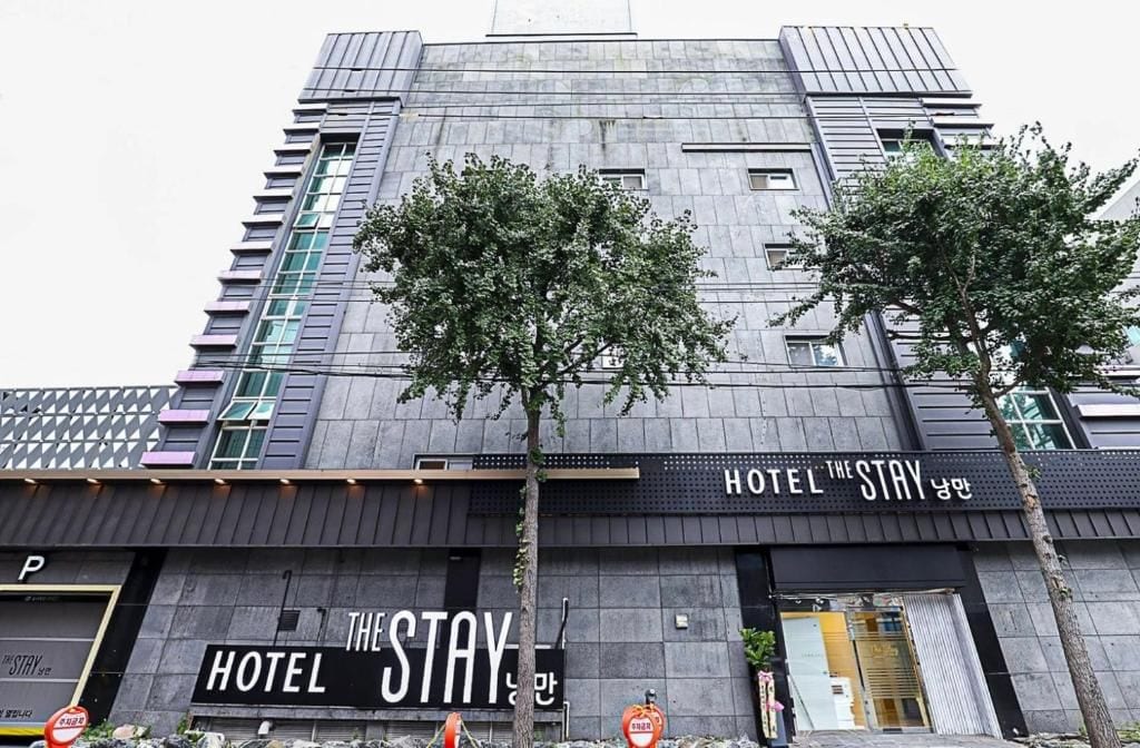A modern hotel building with a prominent sign reading 'HOTEL THE STAY' and a visible entrance.
