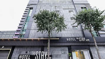 A modern hotel building with a prominent sign reading 'HOTEL THE STAY' and a visible entrance.