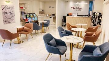 A hotel lobby with seating areas, a reception desk, and a snack corner.