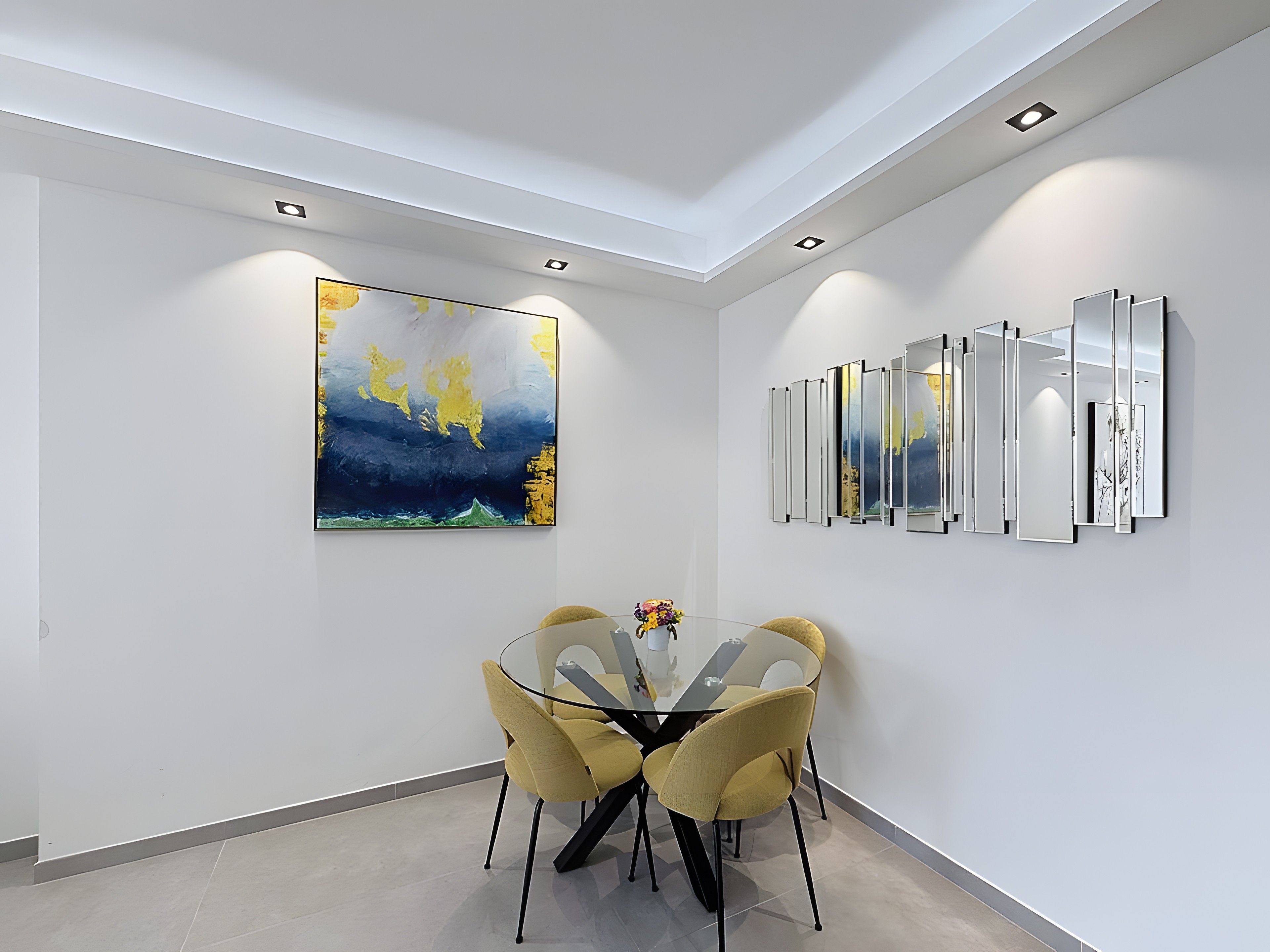 A modern dining area with a glass table, yellow chairs, a large abstract painting, and a series of mirrors on the wall.