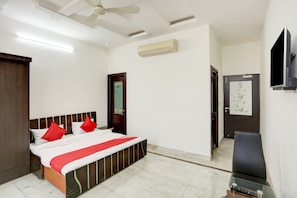 Une chambre d’hôtel équipée d’un lit, d’une télévision, d’un climatiseur et d’une porte.