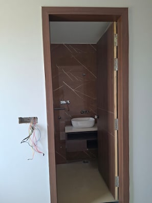 A bathroom with a white sink, a towel rack, and visible plumbing. - Ayodhya Blossom (Ayodhya)