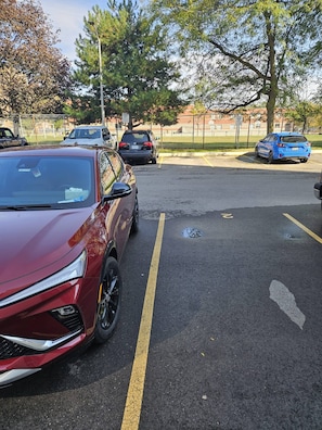 A parking lot with multiple cars, including a red SUV and a blue hatchback. - Luxurious Condo Rental with Private Room in Mississauga (Mississauga)