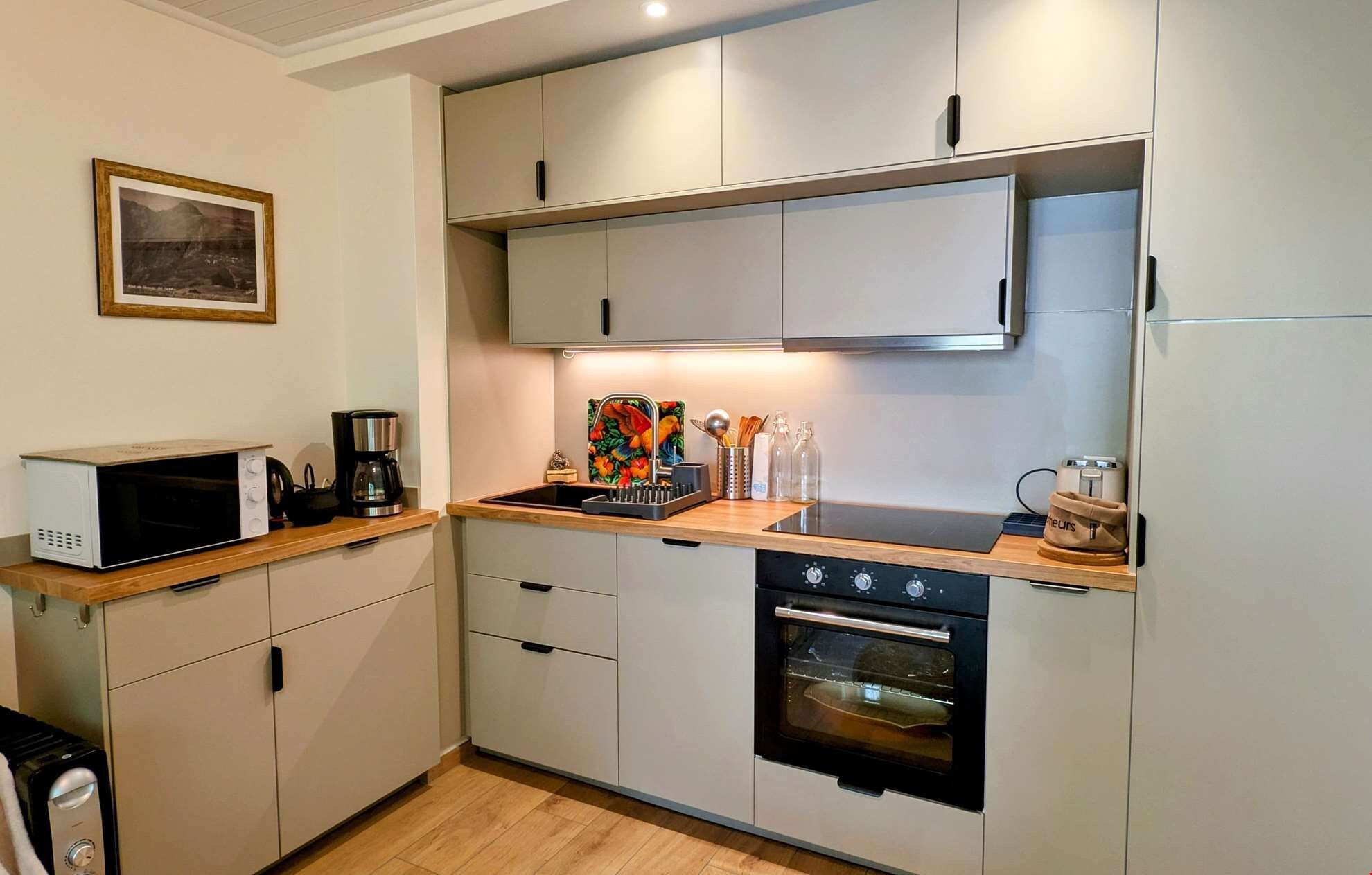 A compact kitchen with a microwave, coffee maker, and a small oven.