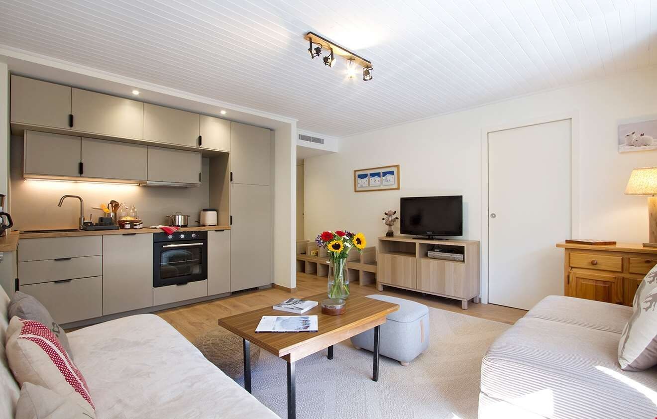 A modern living room with a sofa, a coffee table, and a TV.