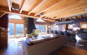 Amplia sala de estar con chimenea, mesa de comedor y asientos cómodos.