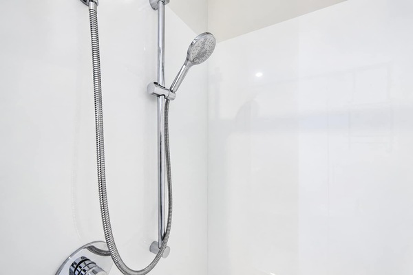 Rinse off beneath the handheld showerhead, mounted on an adjustable rail with a flexible hose and mixer control.