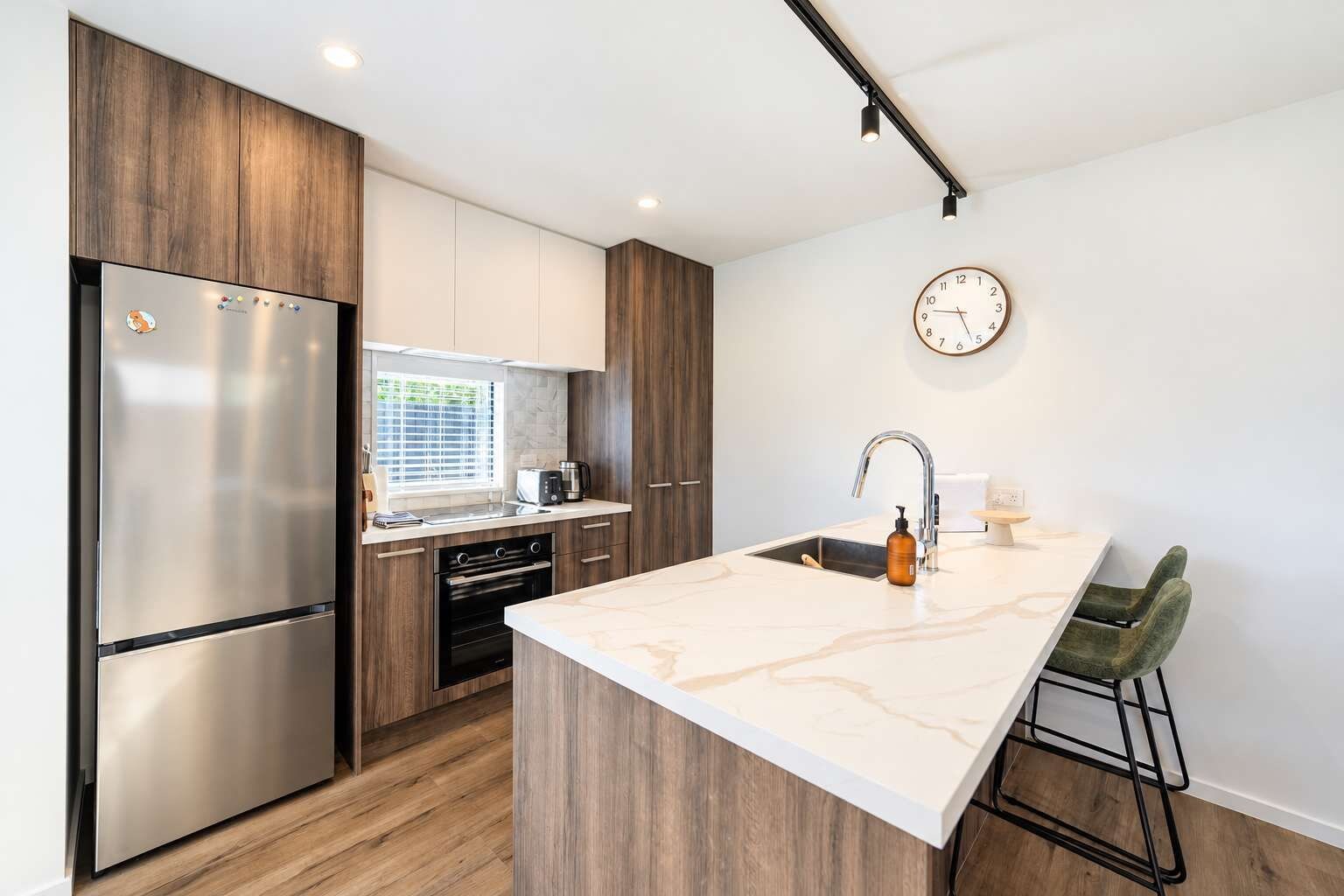 Enjoy the open-plan kitchen and dining area, with a generous island bench, breakfast stools and a round table for shared meals.