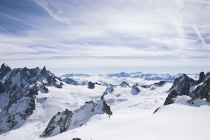 Paisaje montañoso con picos nevados y cielo despejado.