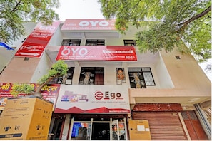 A multi-story building with signs for 'OYO Hotel King Inn Residency' and 'Ego Vision' electronics store. - Hotel O Krishna Residency (Noida)