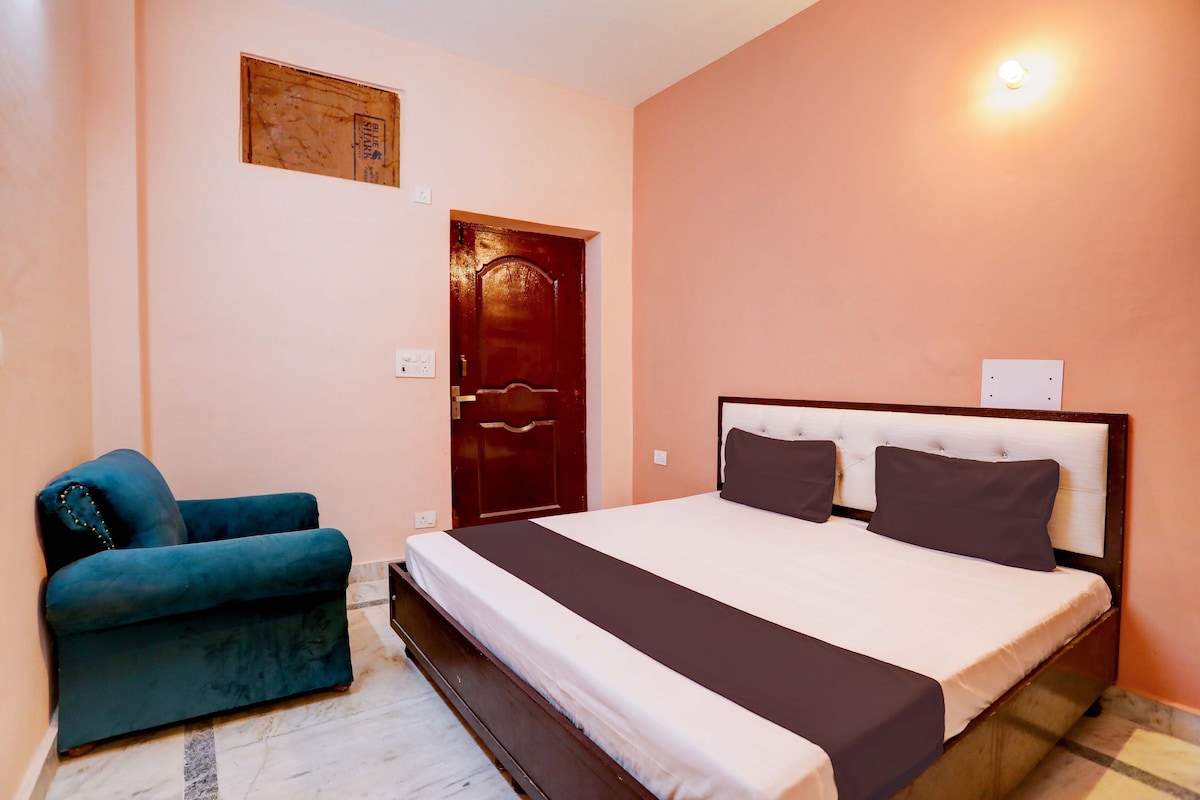 Une chambre à coucher avec un lit, une chaise, une porte et un luminaire fixé au mur.