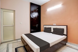 Une chambre à coucher avec un lit, une armoire et un luminaire.