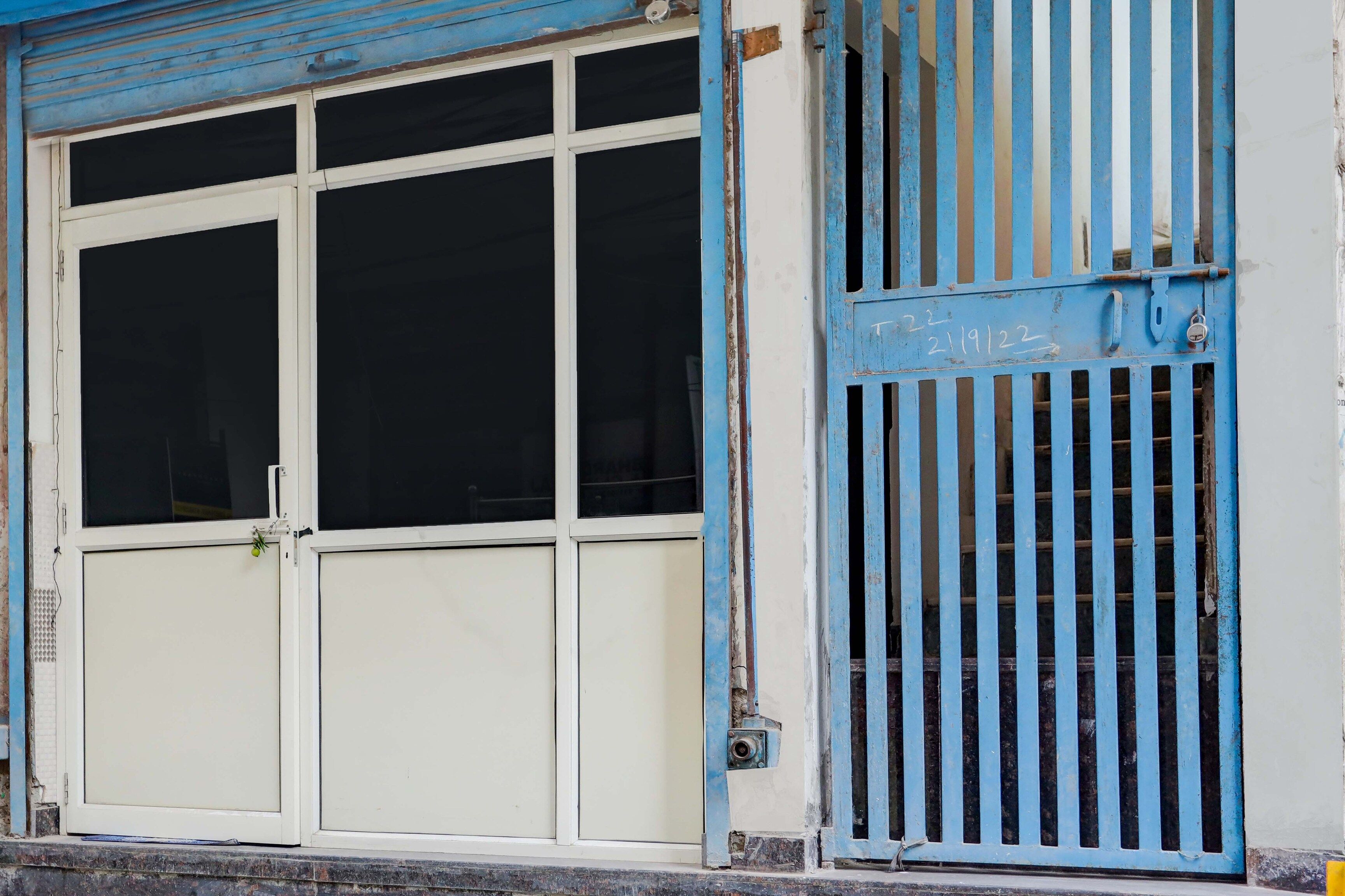 A building facade with a large white door and a blue metal gate.