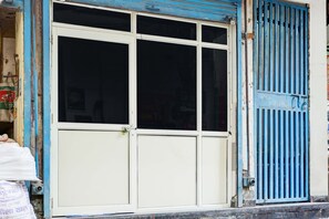 A building facade with a large, white, double-door entrance and a blue metal gate.