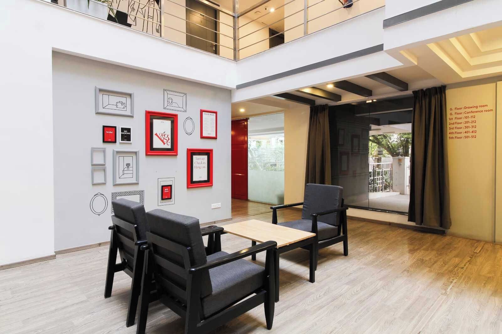 A spacious lobby with a high ceiling, a mezzanine level, and a wall adorned with framed artwork.