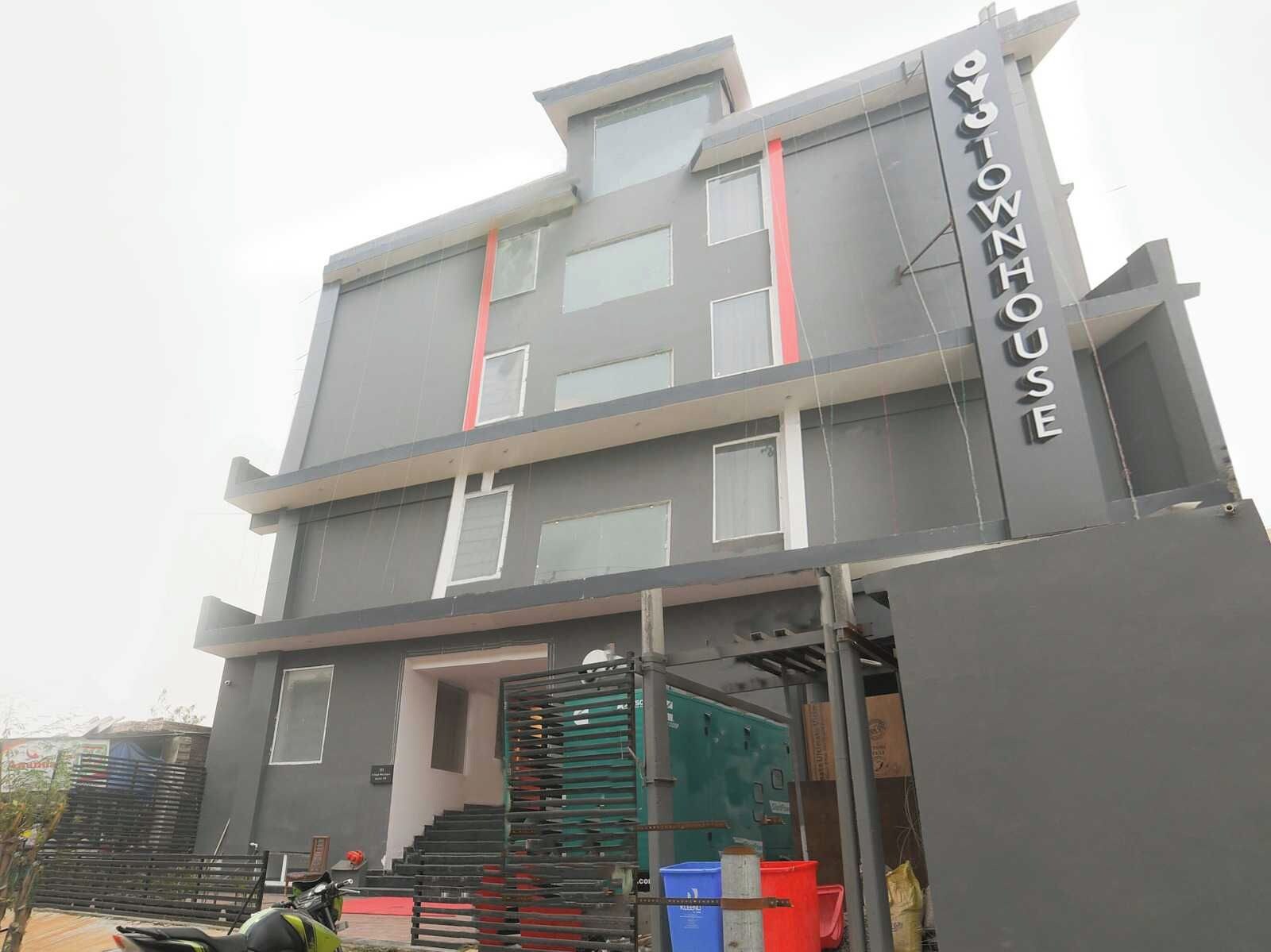 A multi-story building with a prominent sign reading 'OYO TOWNHOUSE'.