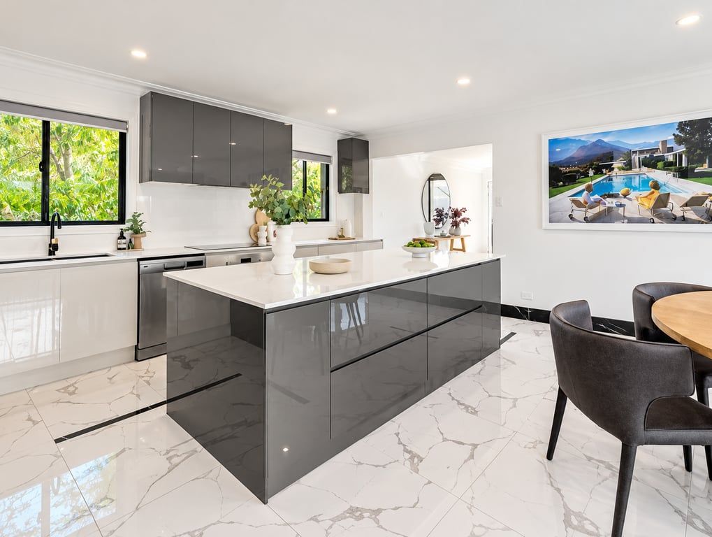 A modern kitchen with a large island, dark cabinetry, and a view of a pool.