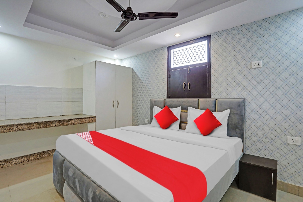 Une chambre à coucher avec un lit, une armoire, un ventilateur de plafond et une fenêtre.