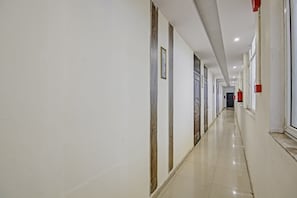 Un pasillo largo y estrecho con puertas a ambos lados, que conduce a habitaciones individuales.