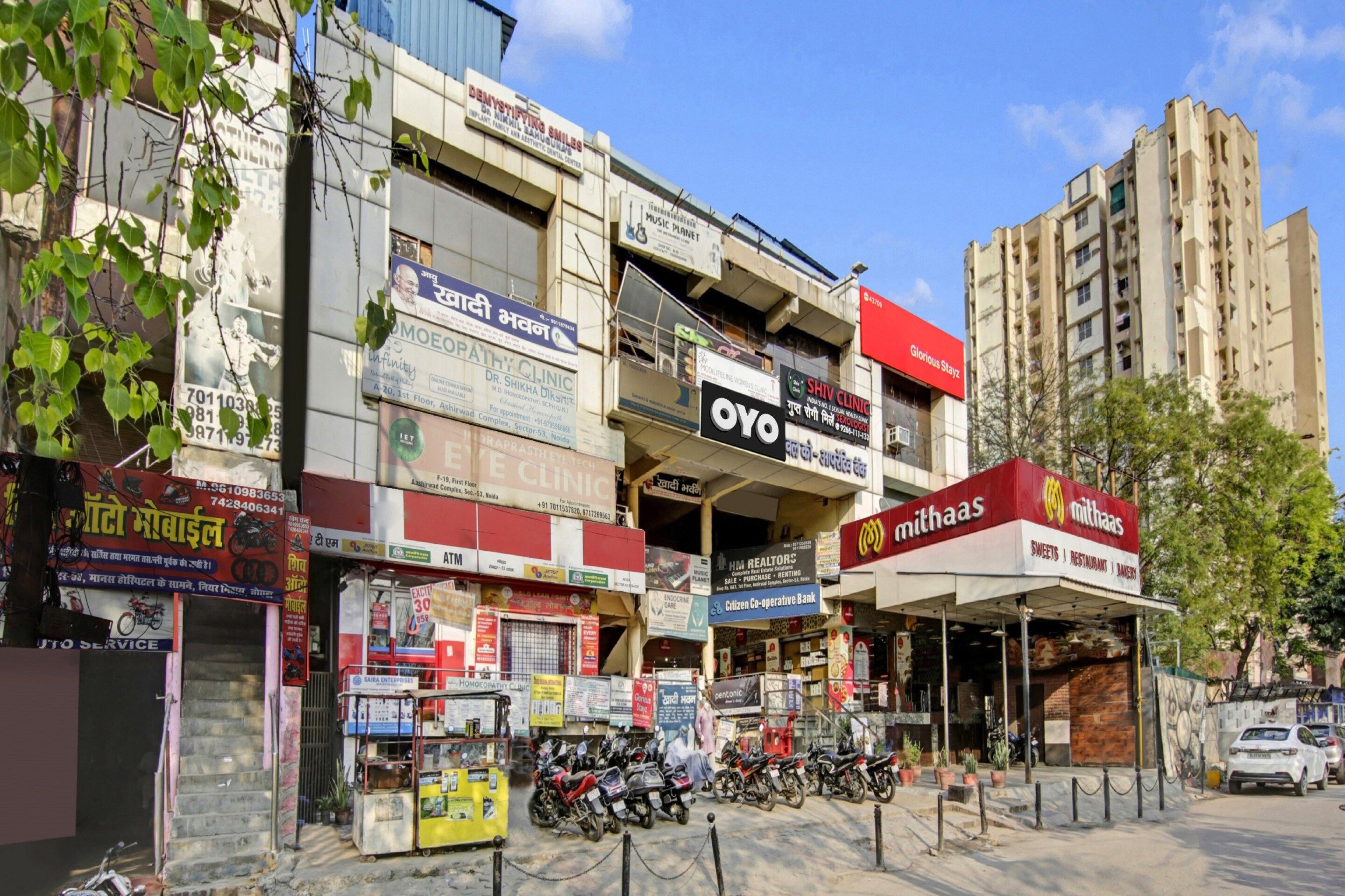 A street view with multiple commercial buildings, including a dental clinic, a bank, and a restaurant.