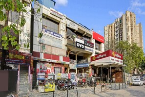 Vista de la calle con varios edificios comerciales, entre ellos una clínica dental, un banco y un restaurante.