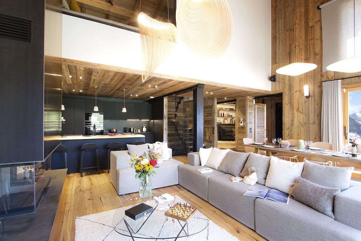 Una sala de estar moderna con un sofá, una mesa de centro y una zona de comedor con mesa y sillas.